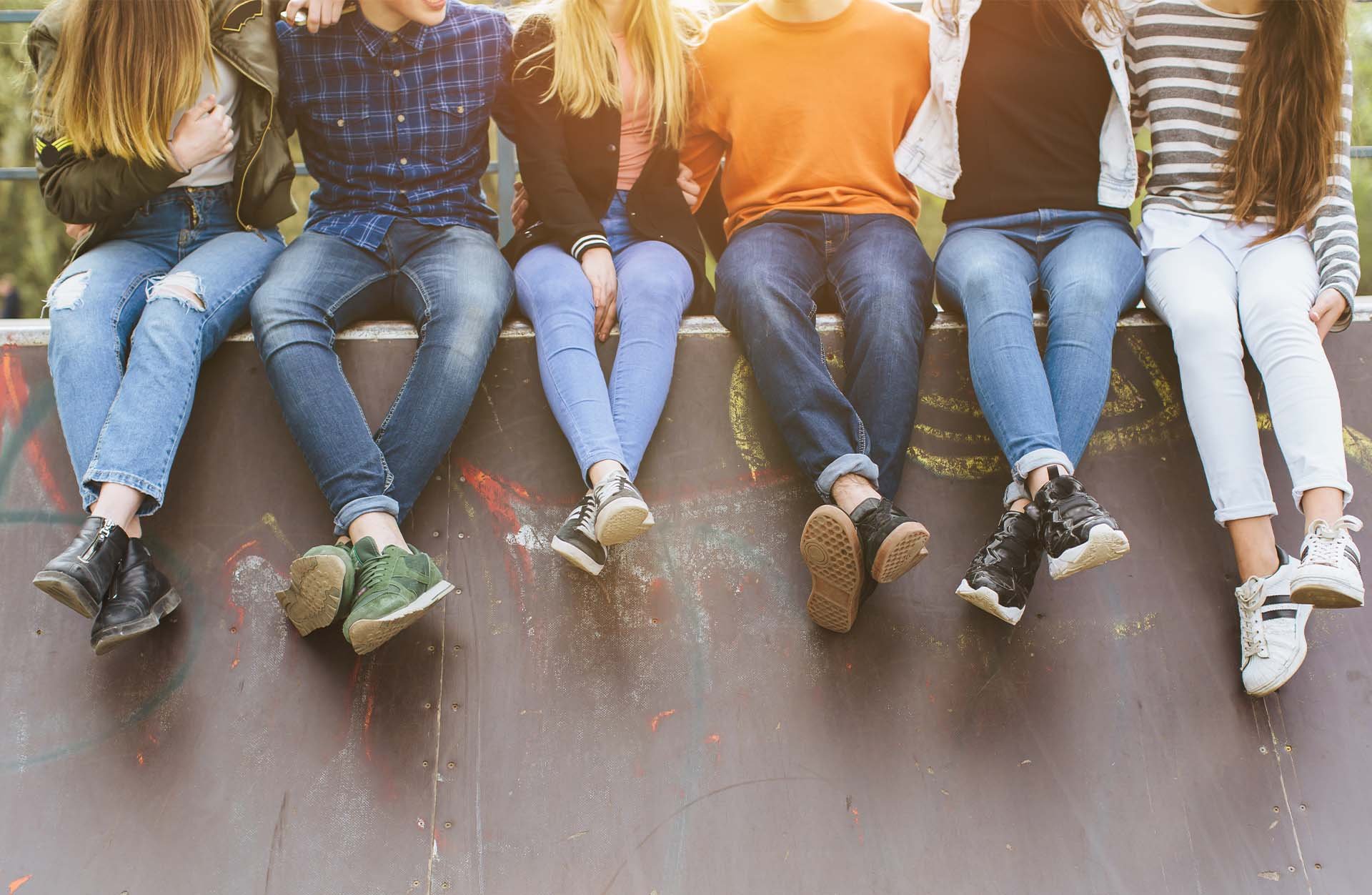 group-of-young-people-sitting-together-at-skatepark