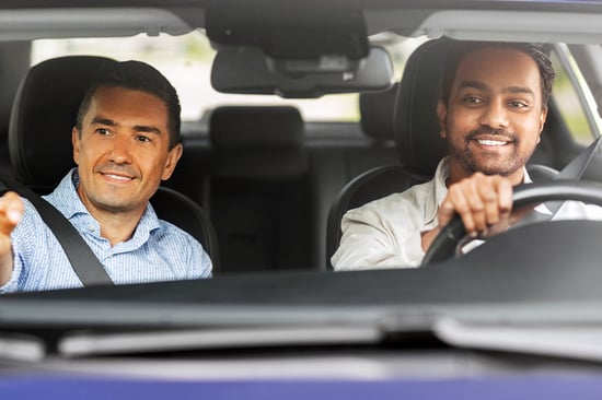 instructor-directing-adult-student-driver-behind-the-wheel