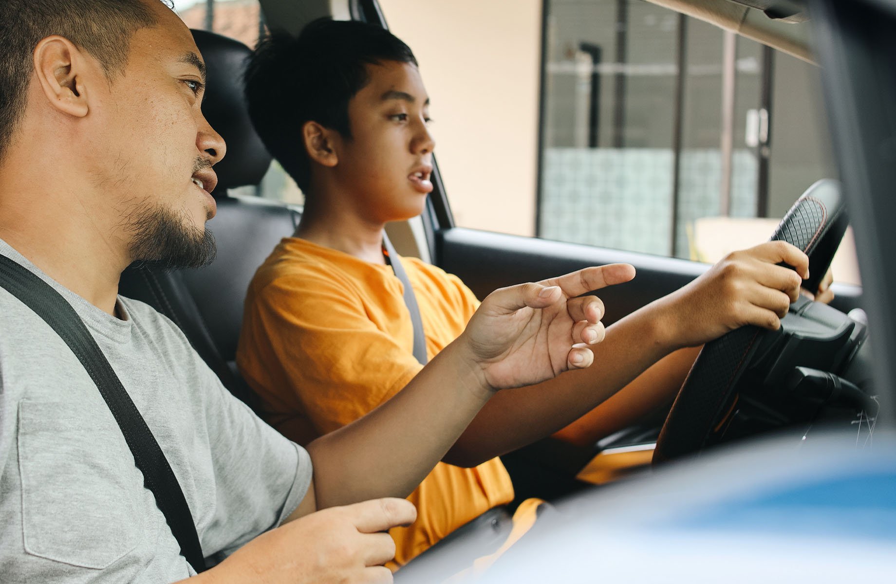 male-teen-behind-wheel-receiving-driving-instruction