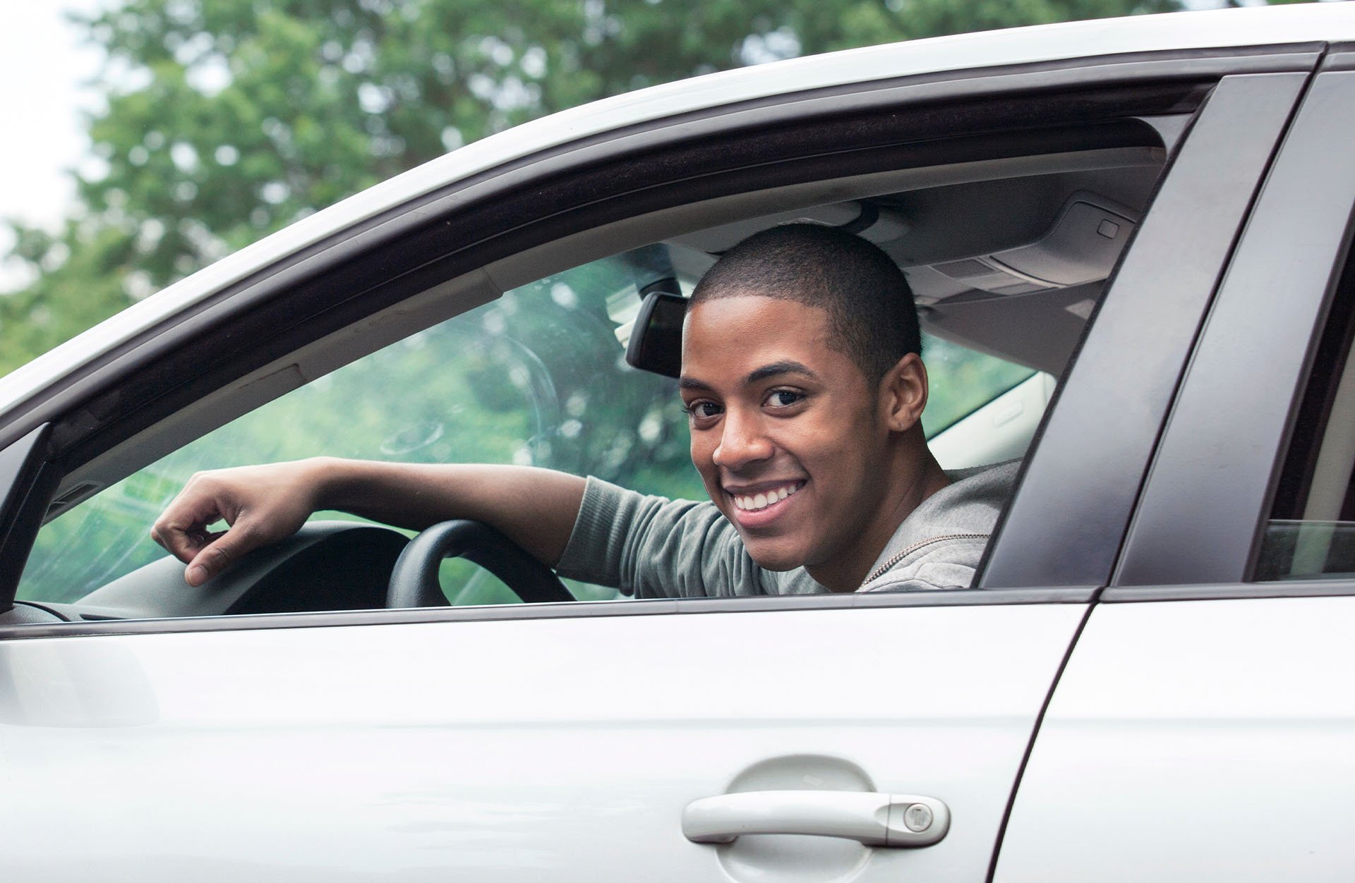 smiling-young-man-sitting-in-parked-car